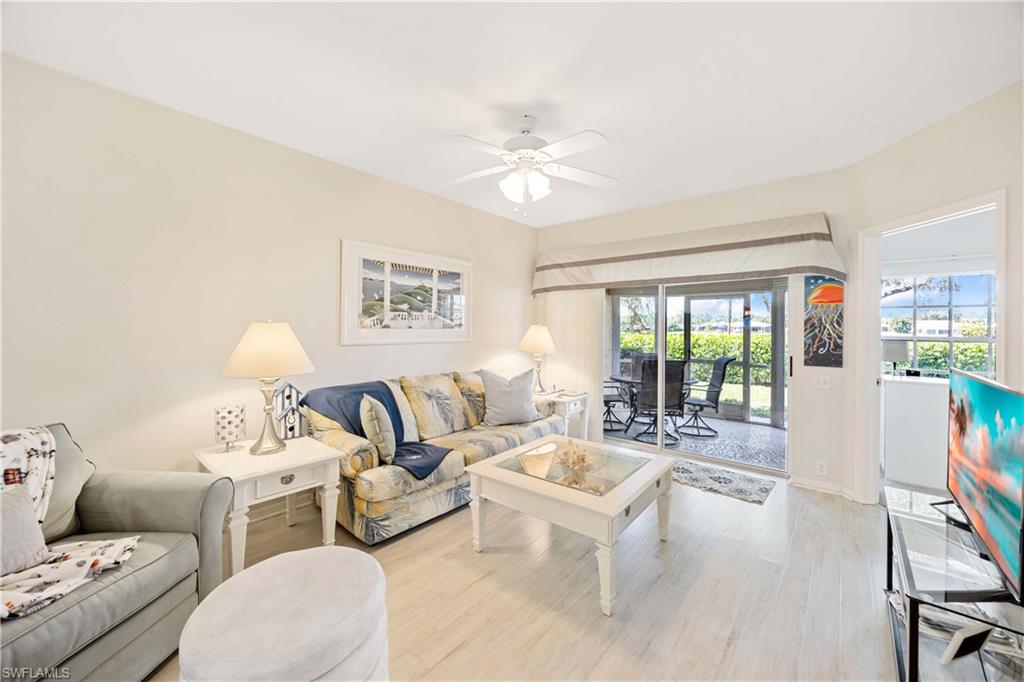 Living room featuring a ceiling fan, light wood-style floors, and baseboards