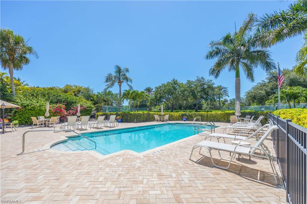 Community pool featuring a patio and fence