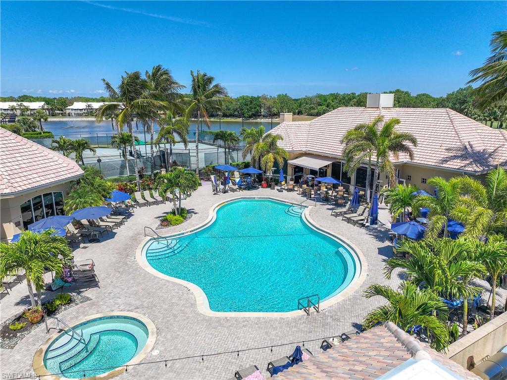 Community pool with a patio area, a water view, and fence