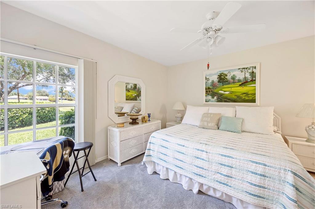 Bedroom with light carpet, a ceiling fan, and baseboards
