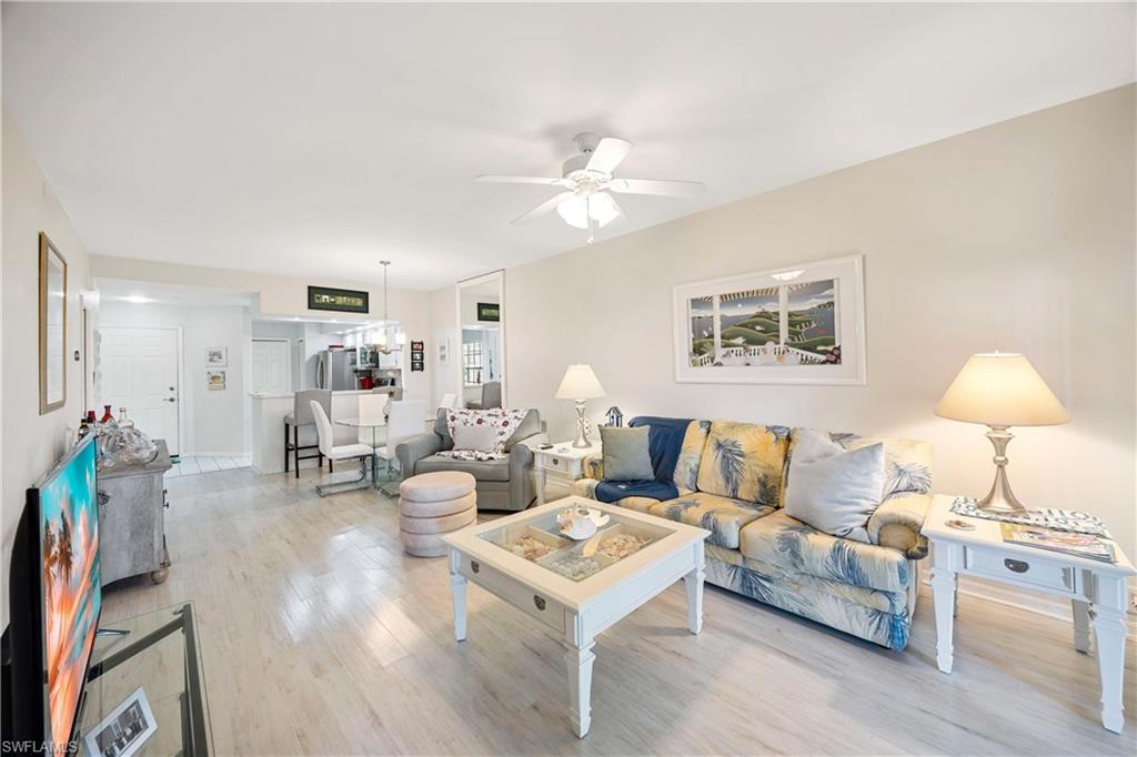Living area with light wood-style floors and a ceiling fan