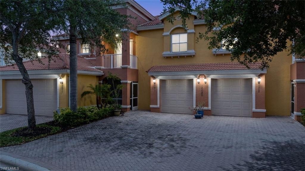 Mediterranean / spanish home featuring decorative driveway, stucco siding, a tiled roof, and an attached garage