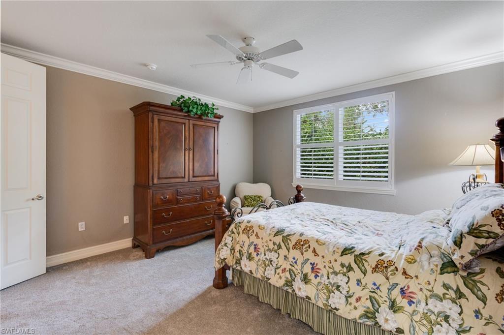 Bedroom featuring crown molding, light colored carpet, and a ceiling fan