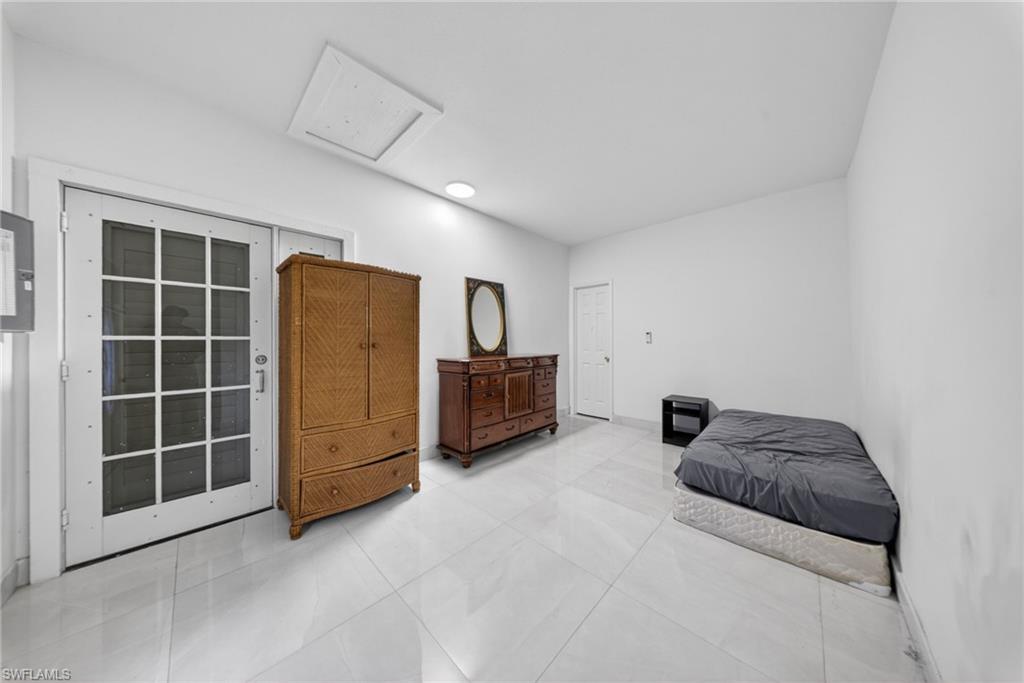 Bedroom featuring electric panel and access to exterior