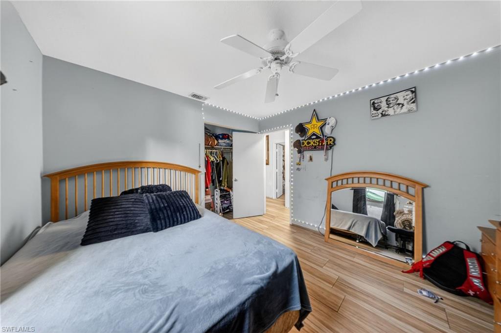 Bedroom with light wood finished floors, a ceiling fan, and a closet