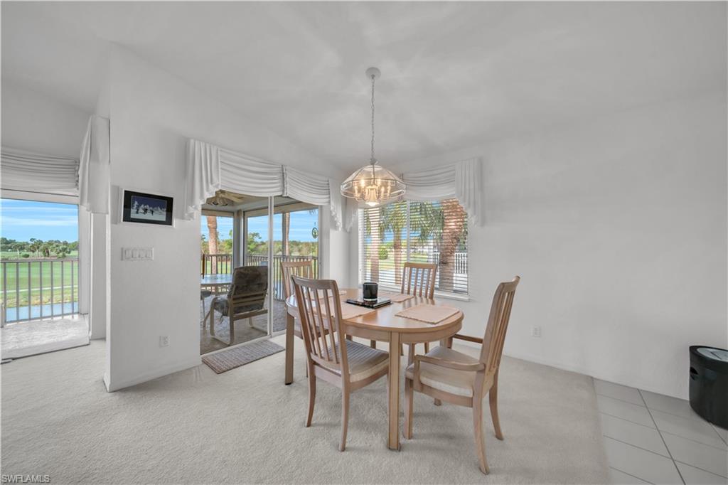 Dining space featuring light colored carpet and suspended lighting