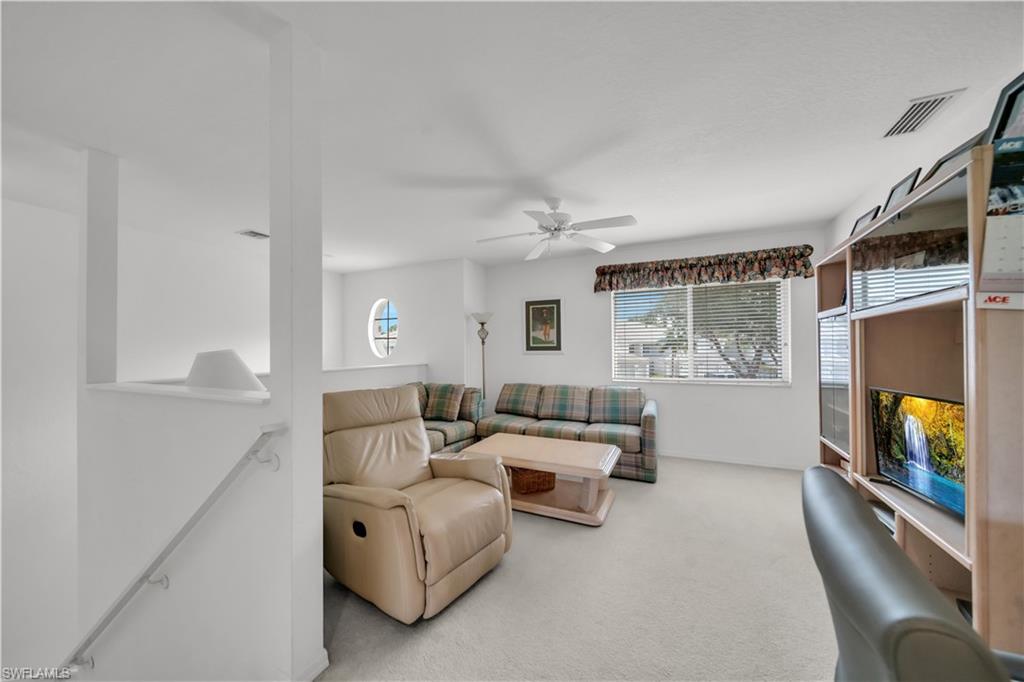 Living room with plenty of natural light, ceiling fan, and carpet