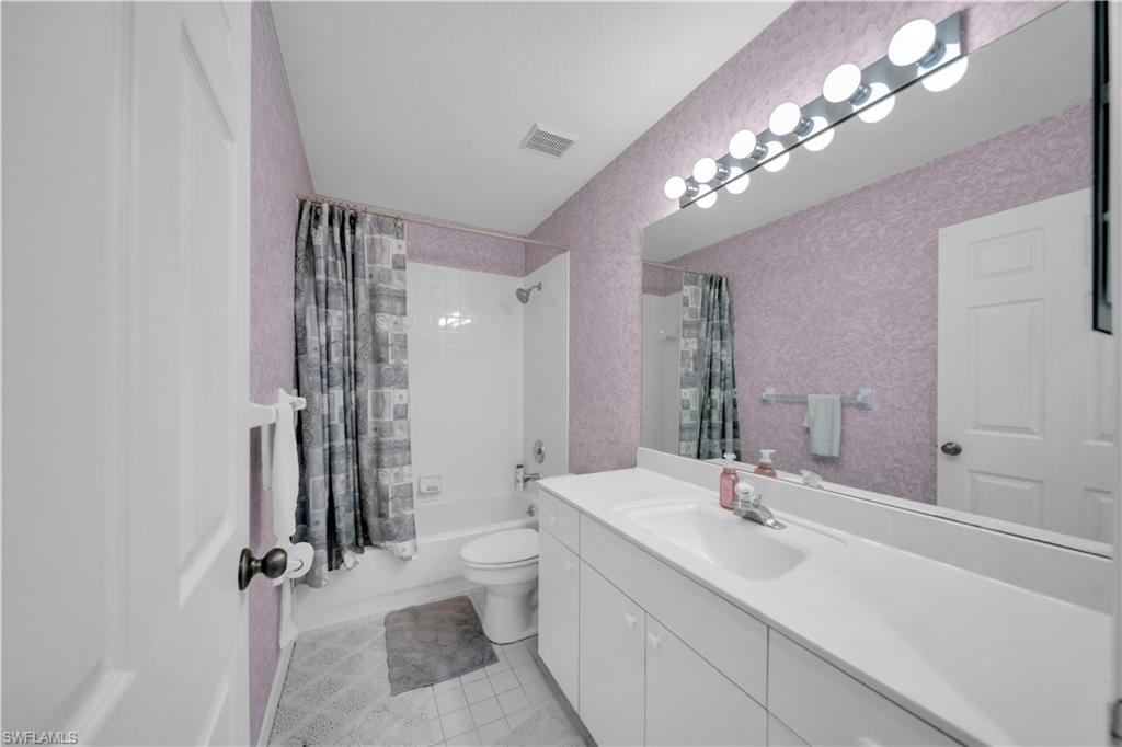 Full bathroom with shower / bath combo, vanity, and light tile patterned floors