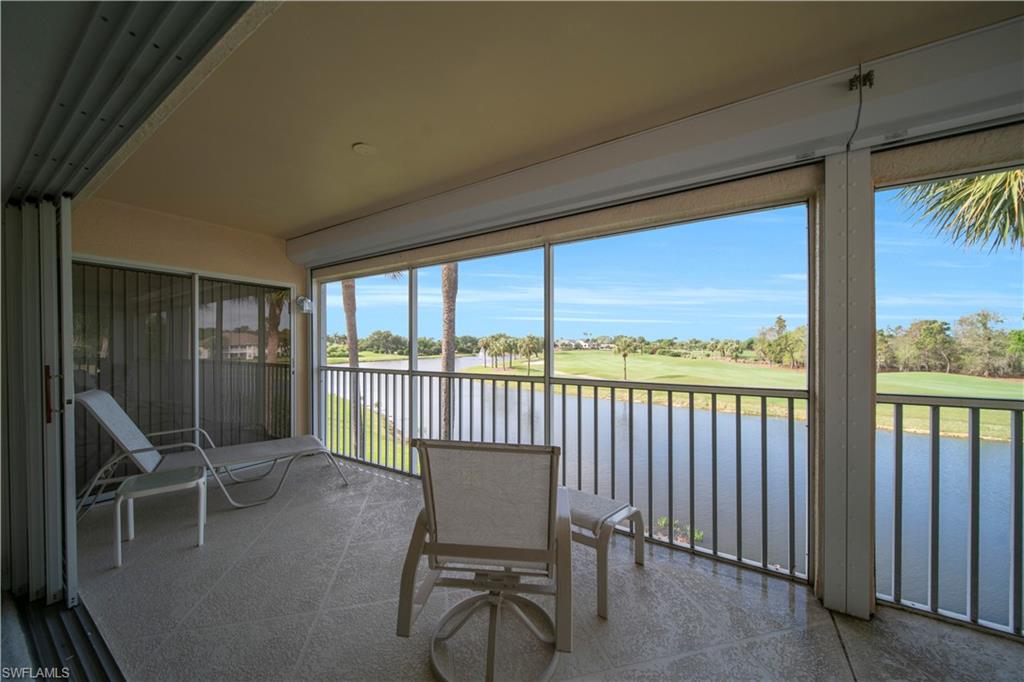 Sunroom with view of golf course and a water view