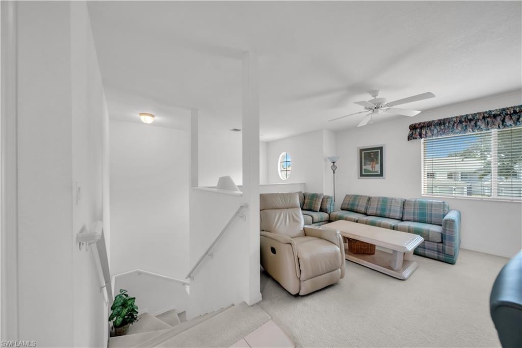Living room featuring carpet flooring and a ceiling fan