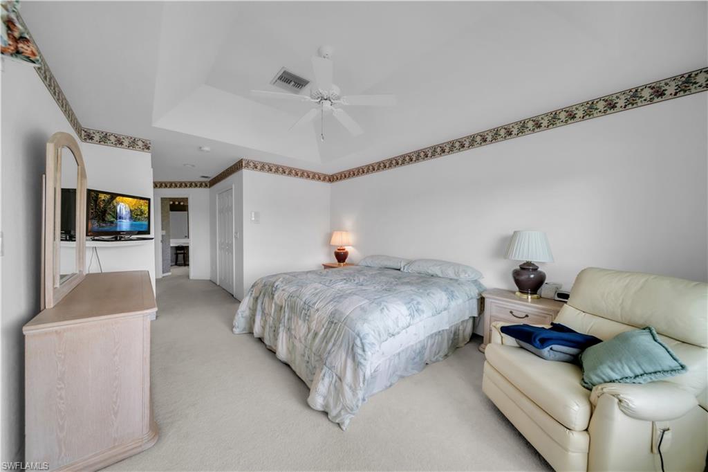 Bedroom with light carpet, a closet, and a ceiling fan