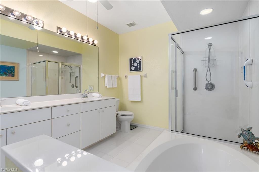 Primary ensuite bathroom with dual vanity, garden tub, walk-in shower and linen closet. Ceramic tile floor.