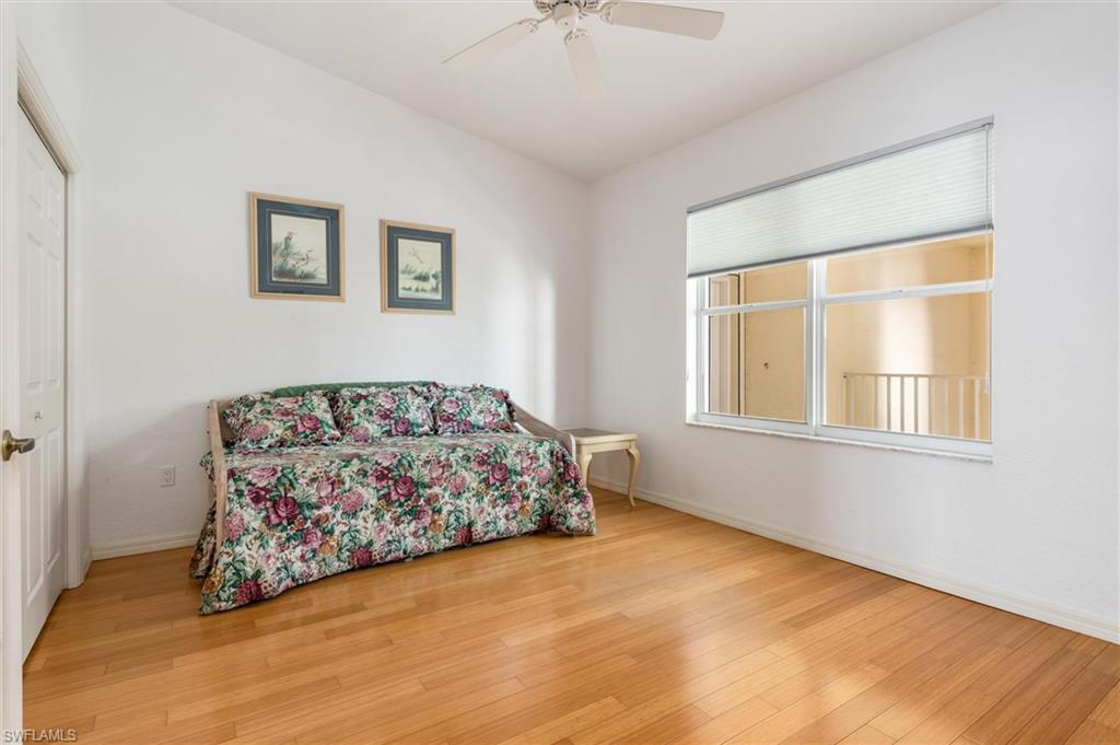 Bedroom featuring double French doors, wood floors, ceiling fan, wood floors, and built-in closet.