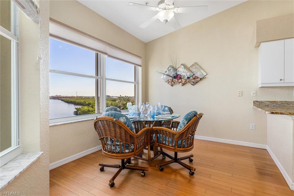 Dining room featuring vaulted ceiling, hanging lights, and wood floors