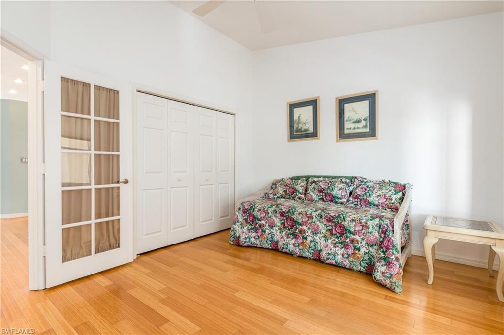 Bedroom featuring double French doors, wood floors, ceiling fan, wood floors, and built-in closet.