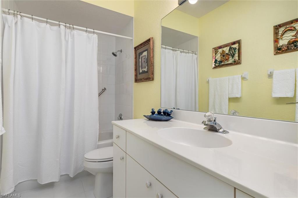 Guest bathroom with vanity, shower/tub combination, and linen closet. Ceramic tile floor.