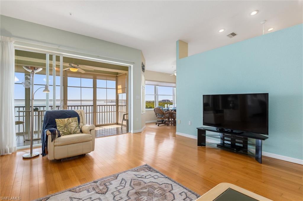 LLiving area with bamboo wood floors, a ceiling fan, and vaulted ceiling