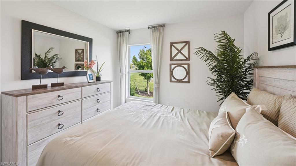 Model Home. This bedroom features a window providing natural light and views of green landscaping