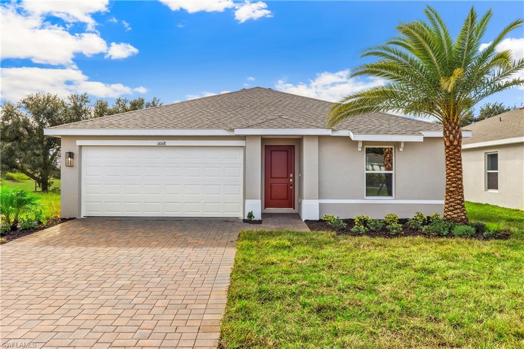 Model Home. The property features a red front door, a paved driveway, and an attached garage