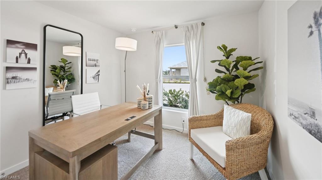 Model Home. This room features neutral-toned carpet, a large window with white curtains, and a floor lamp providing ambient lighting