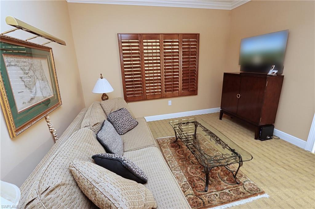 Carpeted living room with ornamental molding