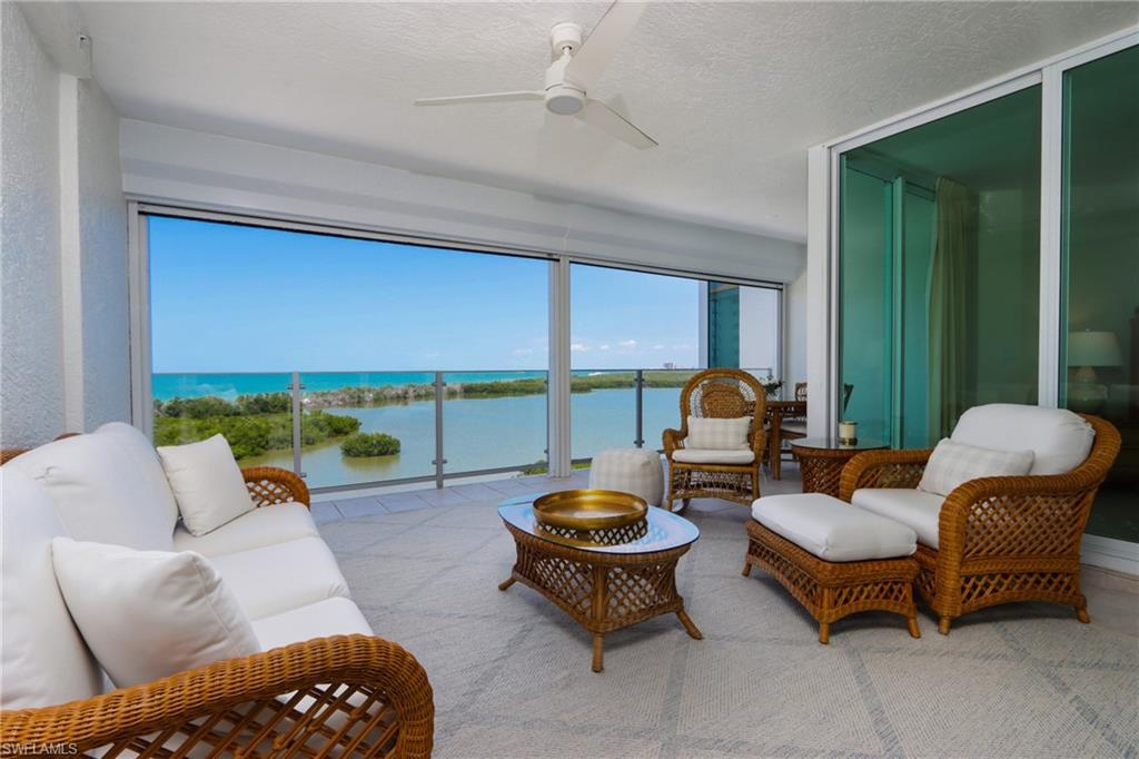 Living room with ceiling fan, a textured ceiling, and a water view