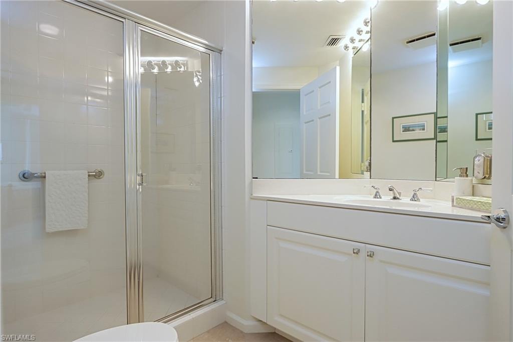 Bathroom with a shower with door, toilet, and vanity