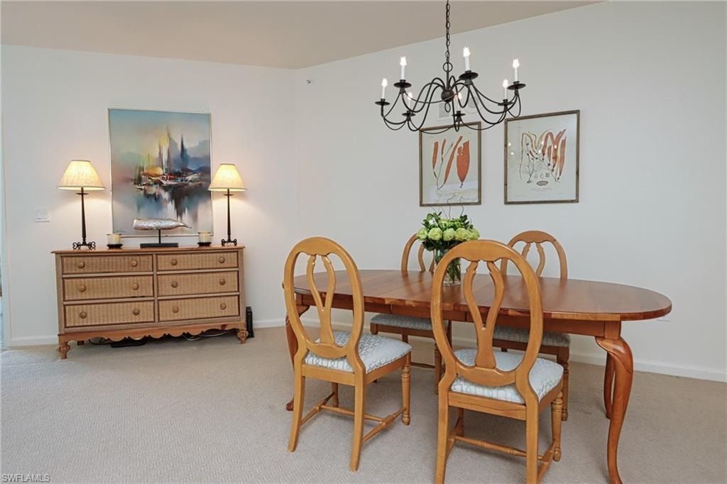 Carpeted dining room featuring a notable chandelier