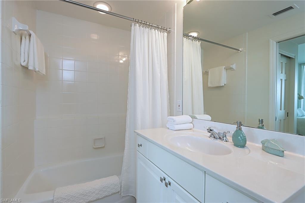 Bathroom with shower / tub combo with curtain and vanity
