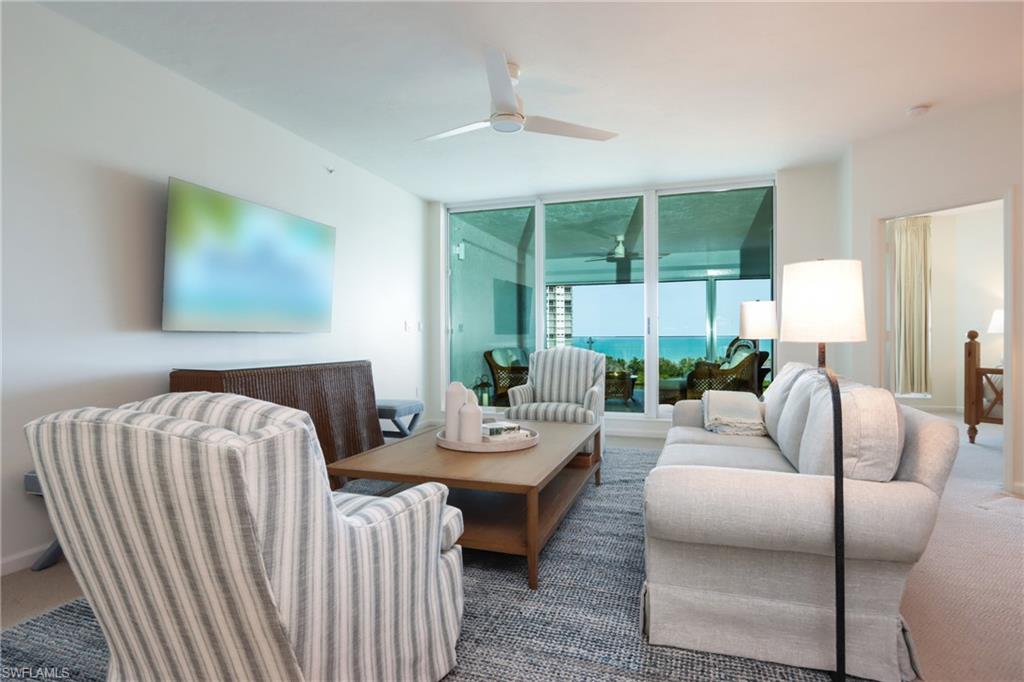 Carpeted living room with ceiling fan