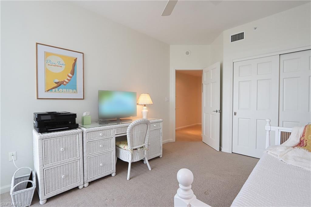 Carpeted home office featuring ceiling fan