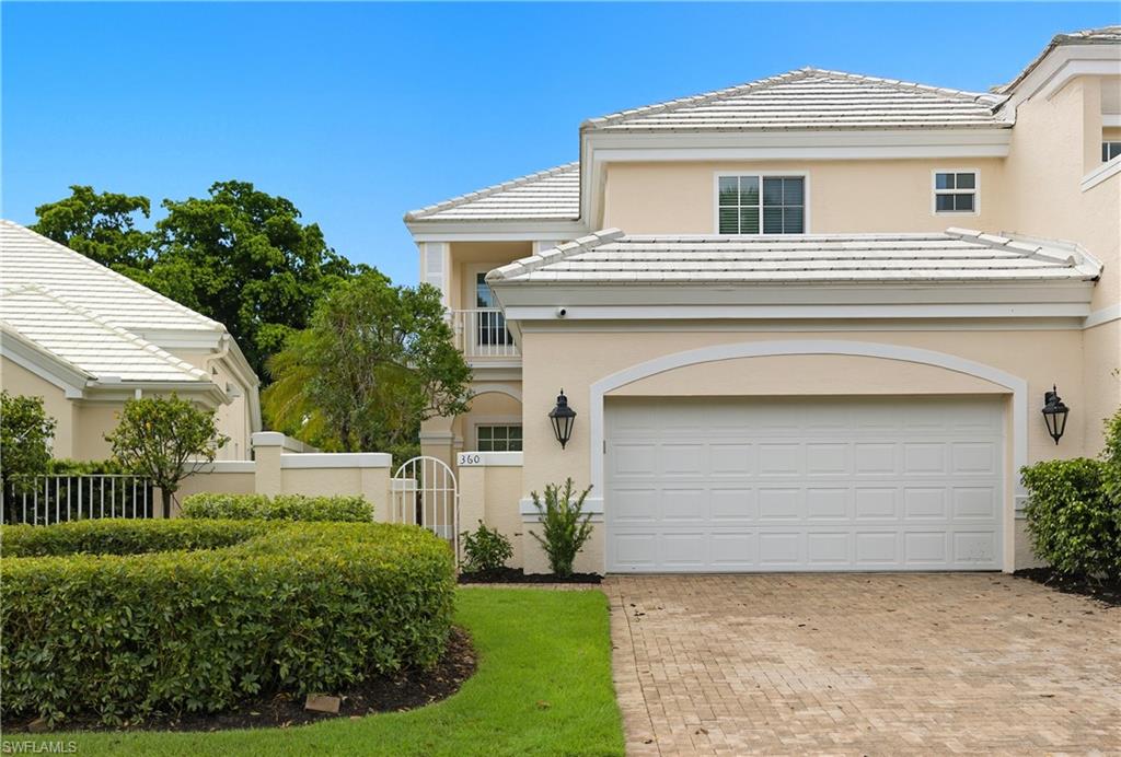View of front of property with a balcony, stucco siding, decorative driveway, and a tile roof