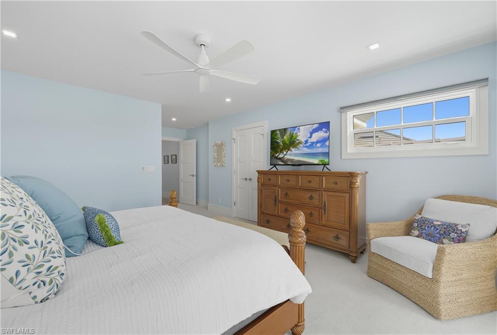 Bedroom with light carpet, ceiling fan, and recessed lighting