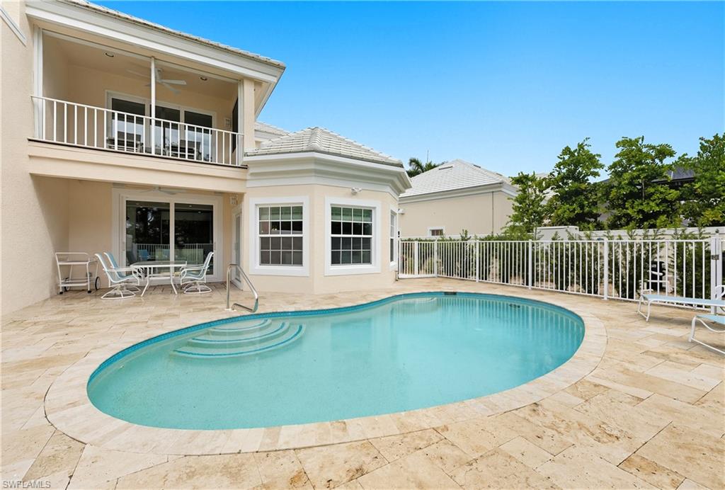 View of pool featuring a patio, a ceiling fan, a balcony, and outdoor dining space