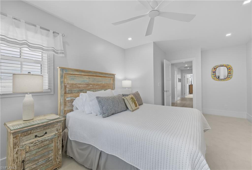 Bedroom with light colored carpet, ceiling fan, and recessed lighting