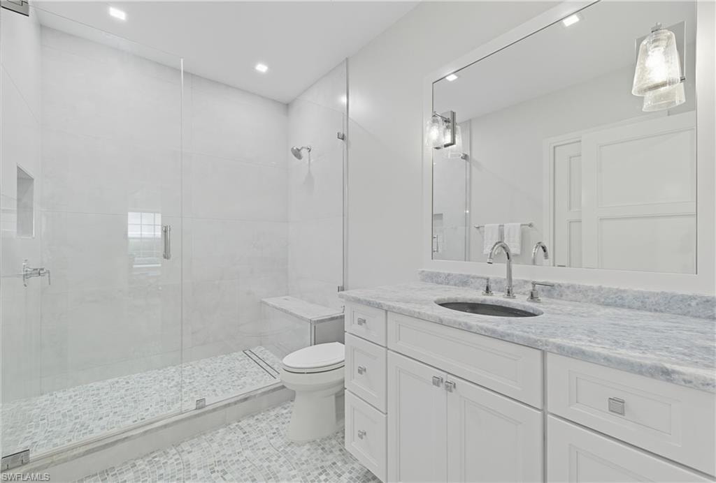 Full bath with a stall shower, vanity, light tile patterned floors, and recessed lighting