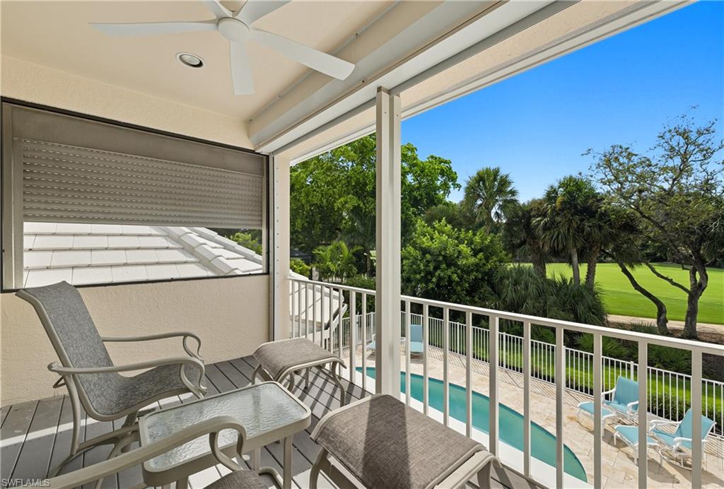 Balcony with view of pool and a ceiling fan