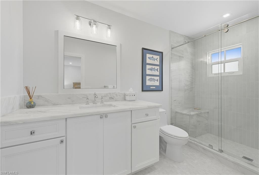Full bathroom with vanity and a stall shower