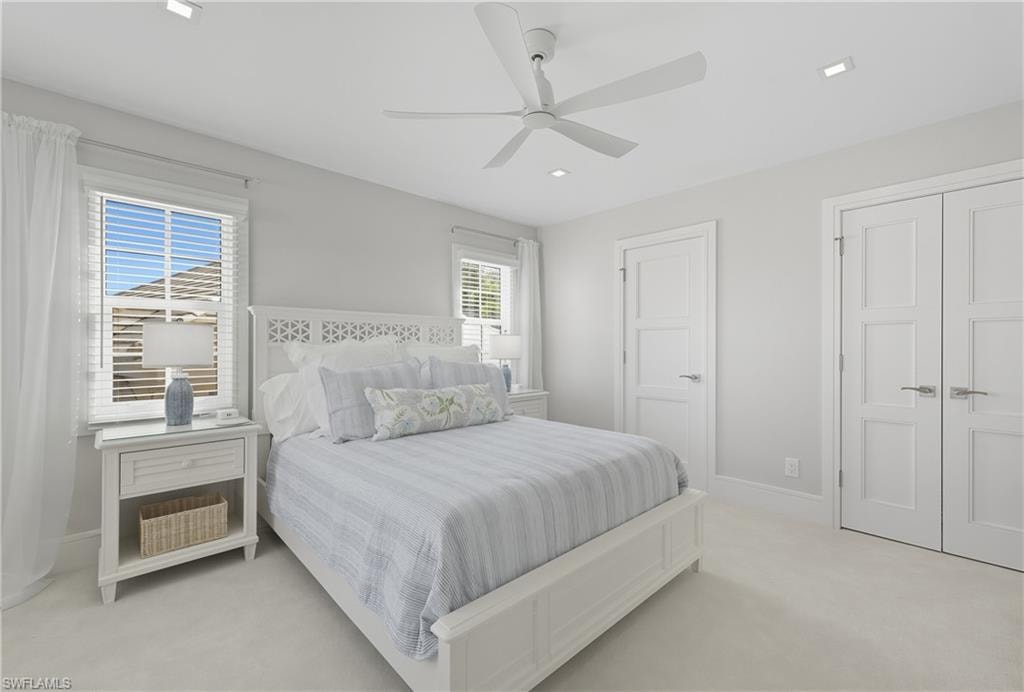 Bedroom featuring light colored carpet, ceiling fan, a closet, and recessed lighting