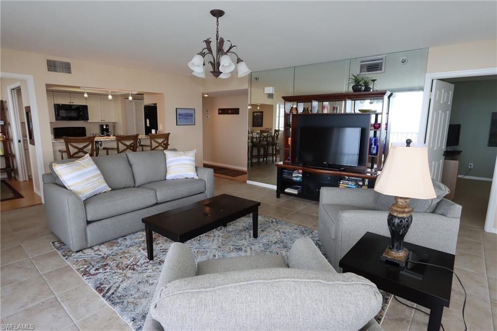 Tiled living room featuring a notable chandelier