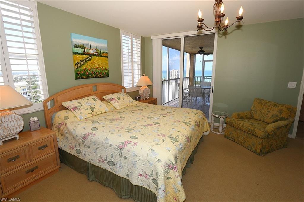 Carpeted bedroom featuring an inviting chandelier and access to exterior
