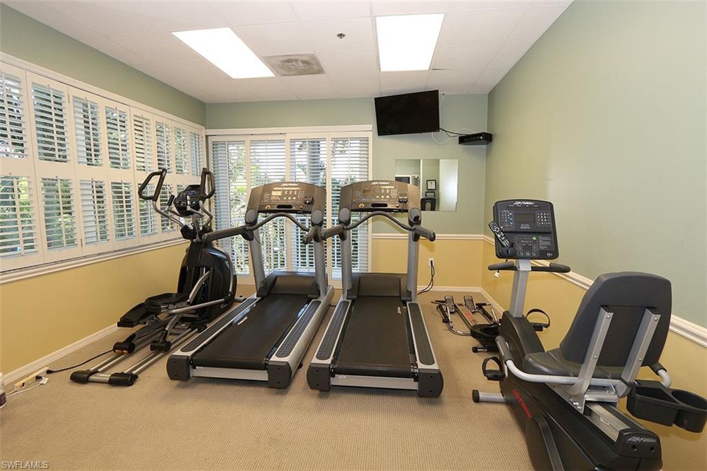 Gym with carpet and a paneled ceiling