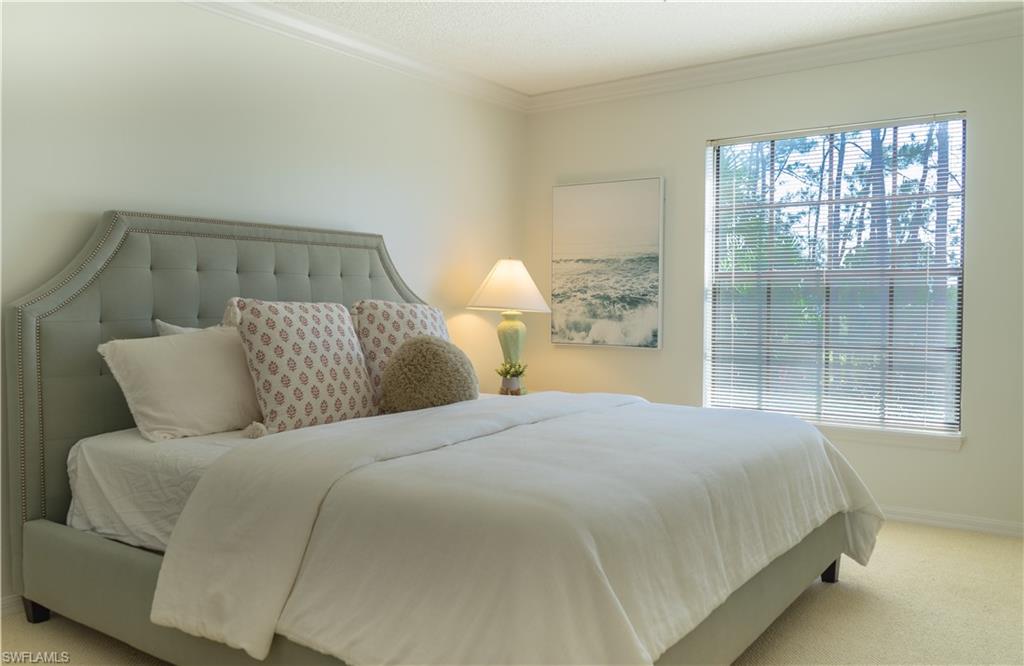 Carpeted bedroom with baseboards and ornamental molding