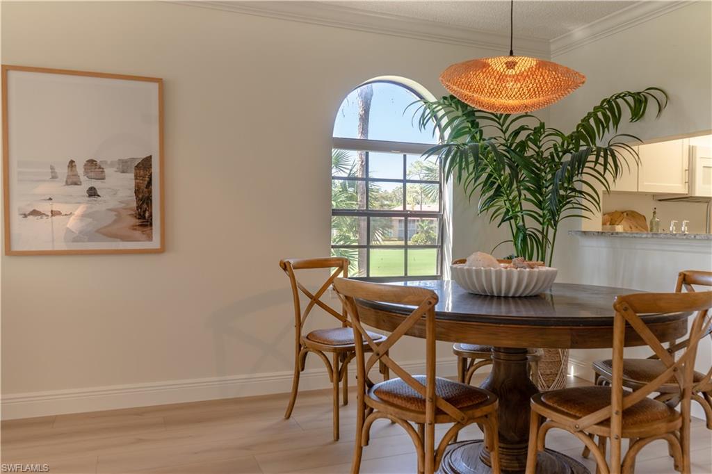 Dining room featuring light wood-style floors, baseboards, and ornamental molding
