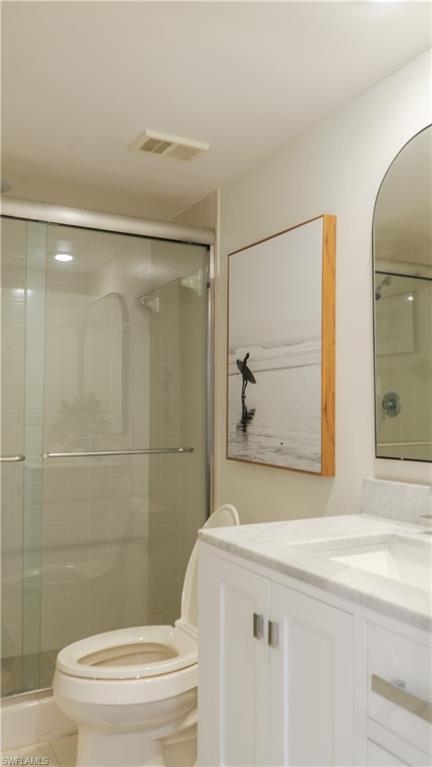 Bathroom with visible vents, toilet, a shower stall, and vanity