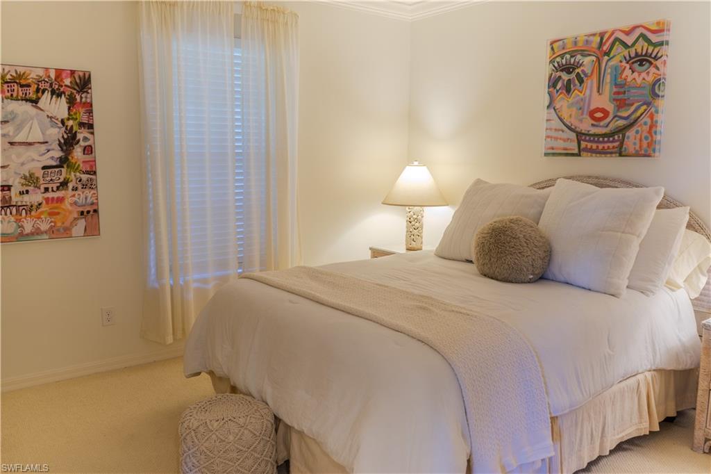 Bedroom with baseboards and light carpet