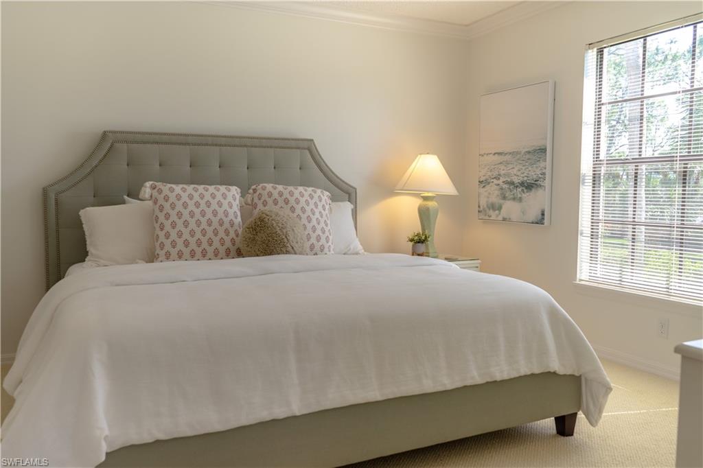 Bedroom featuring crown molding, baseboards, multiple windows, and carpet flooring