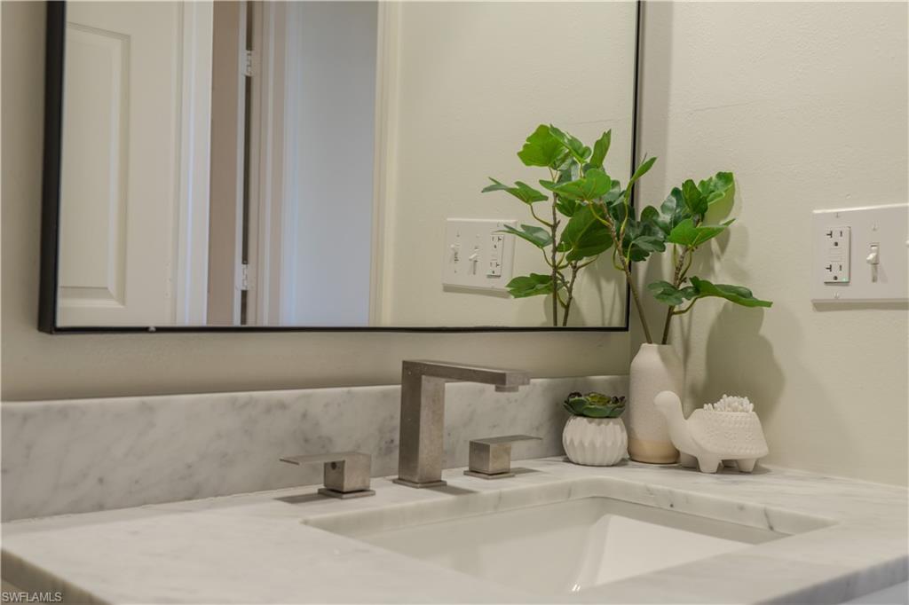Bathroom vanity featuring a white marble countertop and a rectangular undermount sink with a modern brushed nickel faucet