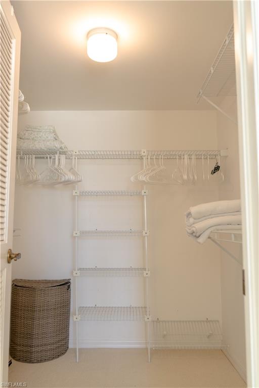 Well-organized closet featuring wire shelving, hanging rods, and a ceiling-mounted light fixture