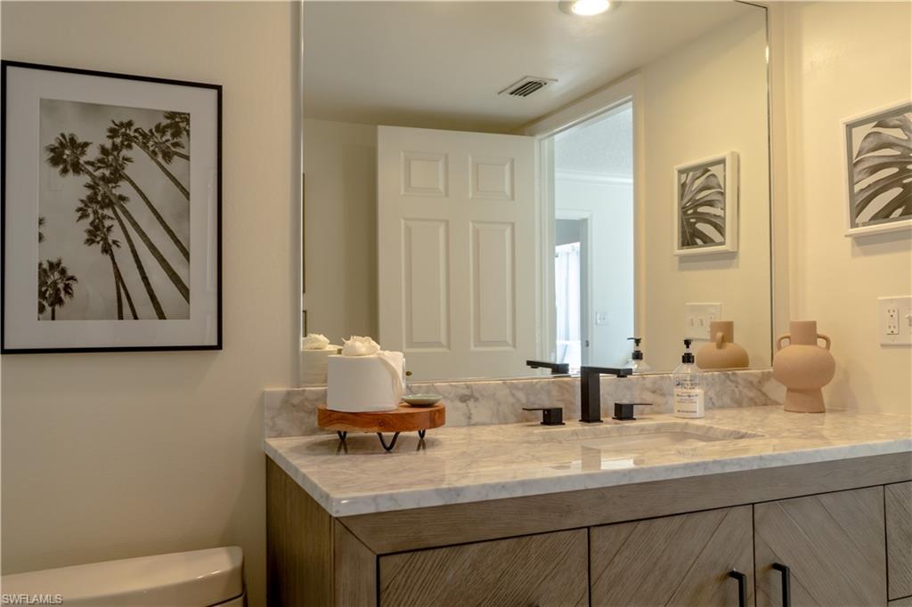 Bathroom featuring a vanity with a light-colored countertop, an integrated sink, and a black faucet